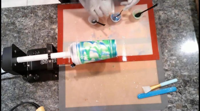 Blue and green mica powder epoxy swirling on a tumbler to match a handmade soap