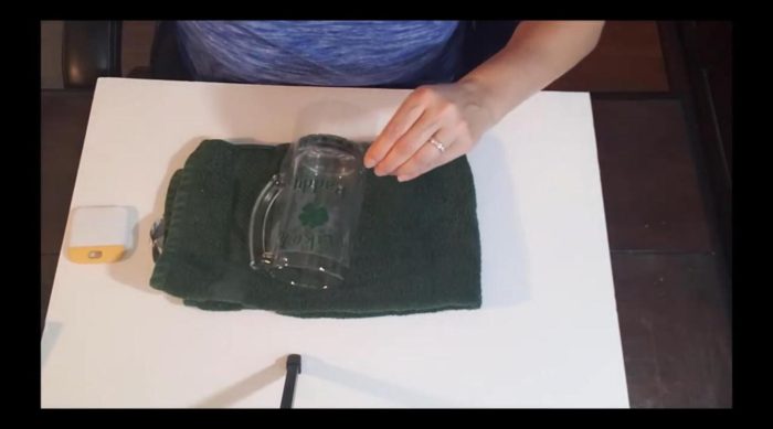 Applying a green shamrock adhesive vinyl decal to a dollar store glass beer mug